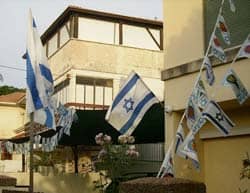 title: residents in Israel celebrate Yom Ha-Atzmaut with flags and banners Source: http://en.wikipedia.org/wiki/File:YomHaatzmautDecorations.jpg