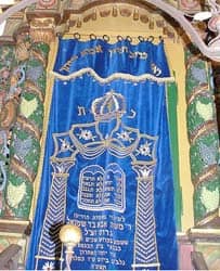 Title: the Aron ha-kodesh, concealing the Torah scrolls behind the curtain Source: http://www.flickr.com/photos/acordova/3189419056/