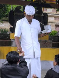 Hindu priest distributes balls of rice